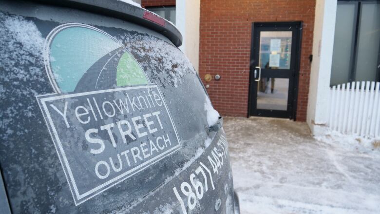 A picture of the Yellowknife street outreach van sighn on the back of the van during winter. 