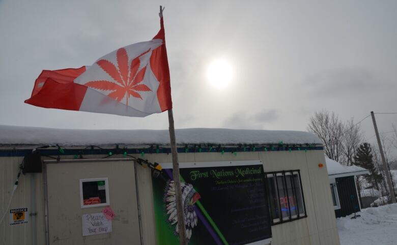 A trailer covered in snow with a Canadian flag featuring a marijuana leaf