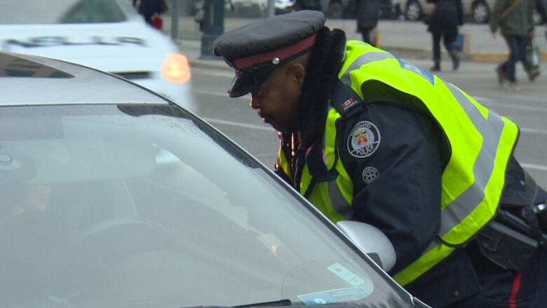 A Toronto police officer talks to a driver downtown.