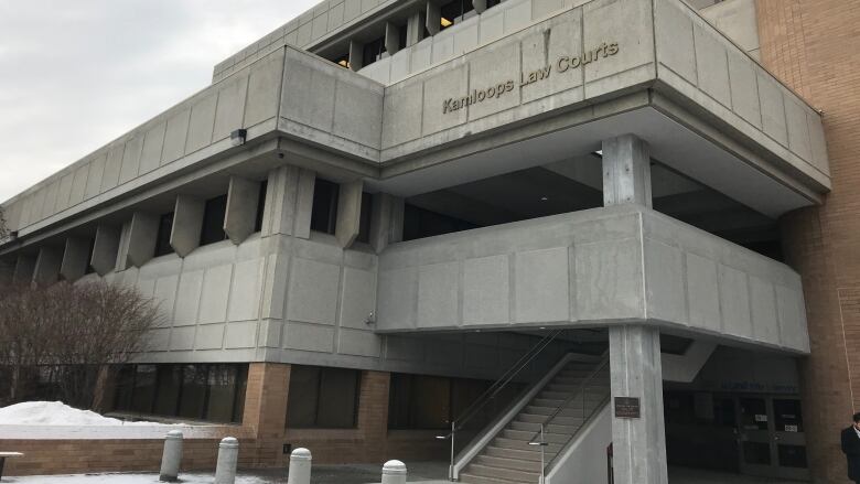 An image of a blocky white building. Lettering reads 'Kamloops Law Courts'.