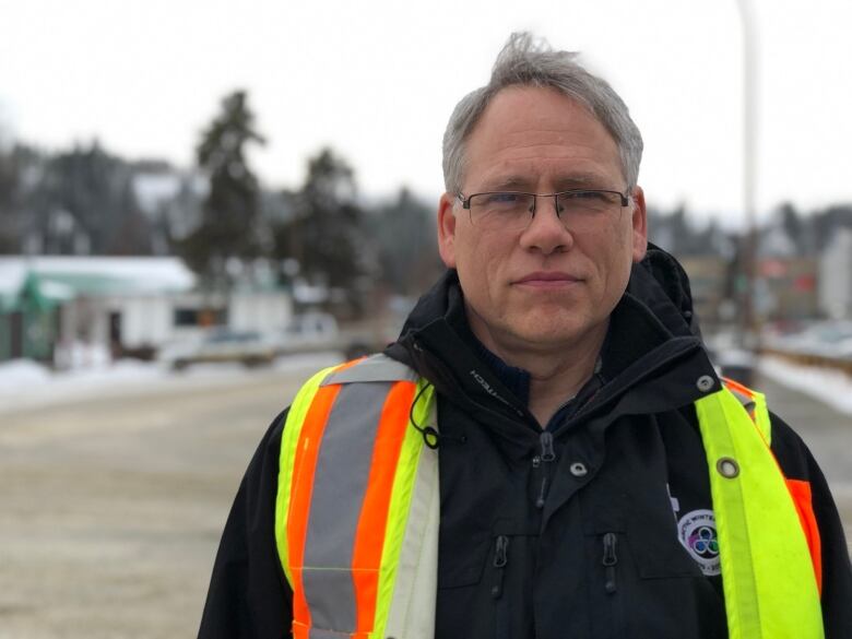 A man wearing a safety vest outside.