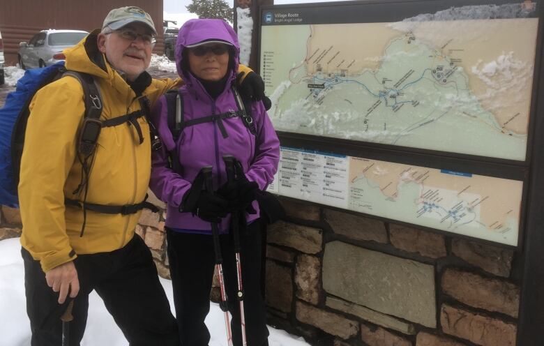 Two people posting by a map.