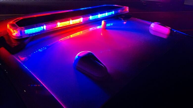 Red and blue lights illuminate the top of a police cruiser. 