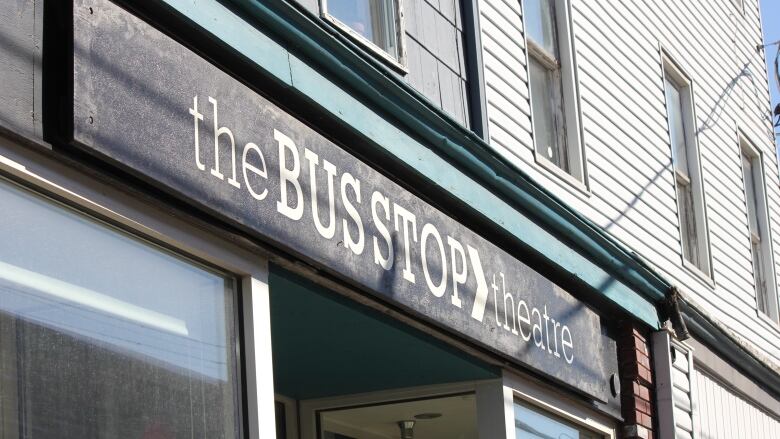 The theatre's black sign is seen with the words Bus Stop Theatre in white lettering