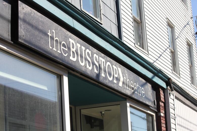 The theatre's black sign is seen with the words Bus Stop Theatre in white lettering