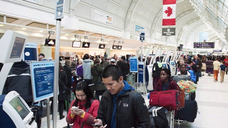 People stand in line at an airport.