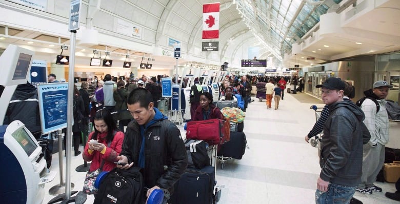 People stand in line at an airport.