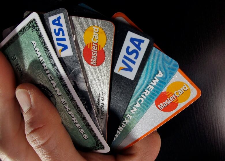 Several credit cards are fanned out in a person's hand.