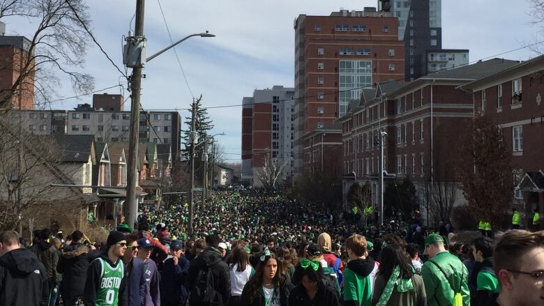 Crowds of students pack the corners of Ezra Avenue as Waterloo Regional Police officers watch for St. Patrick's Day on March 17, 2019