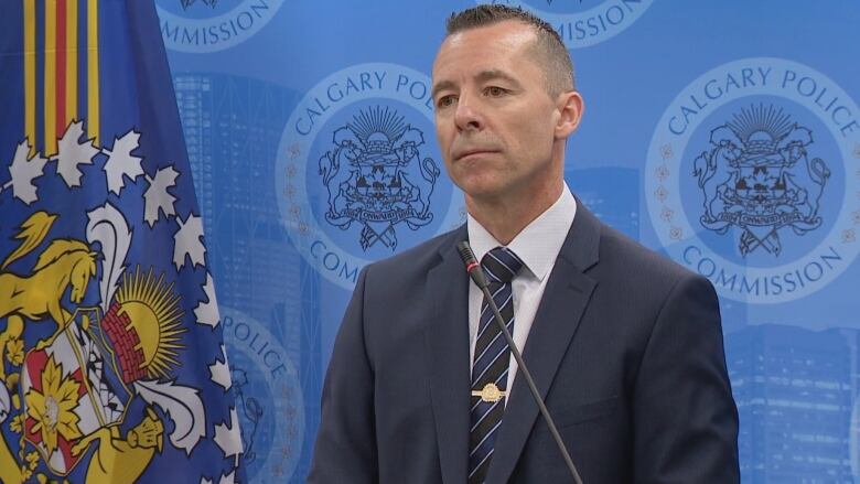 A man wearing a suit is pictured against a blue background with a logo that reads Calgary Police Commission.