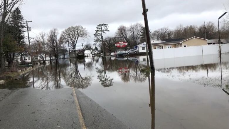 Water pools over both lanes of a street during historic spring flooding.