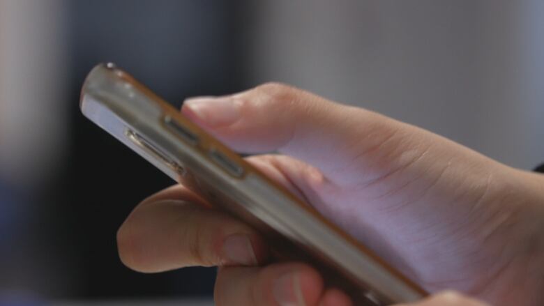 Close-up image of a hand scrolling on a cellphone