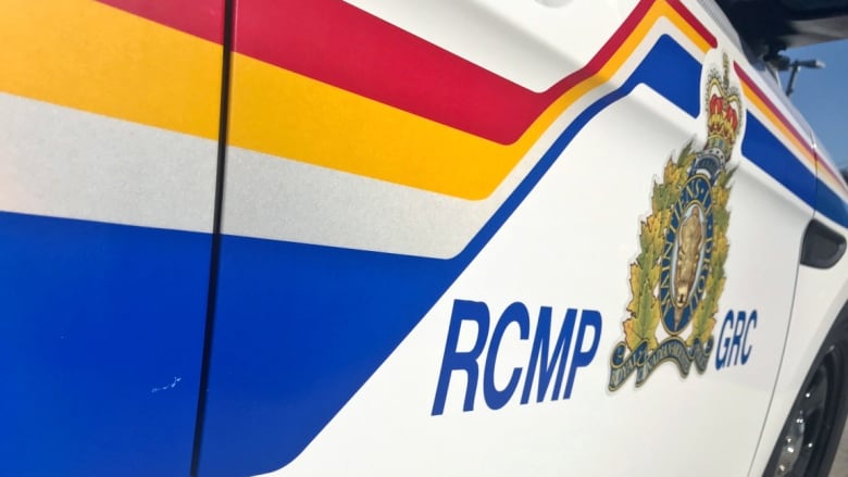 The RCMP logo is shown in close-up on the side of a police cruiser.