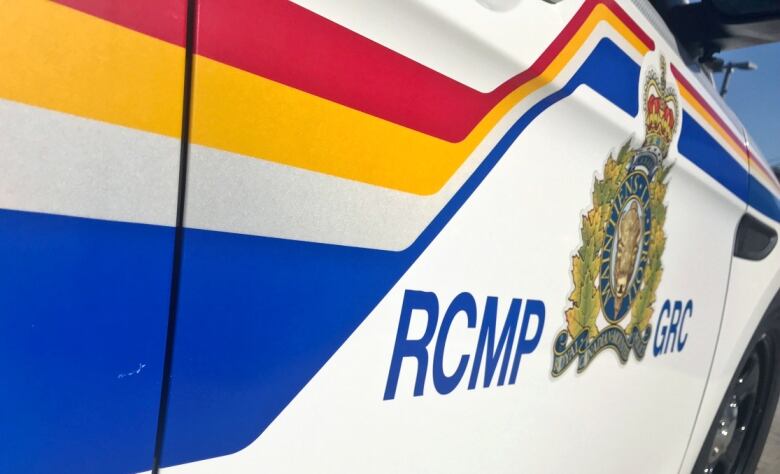 The RCMP logo is shown in close-up on the side of a police cruiser.