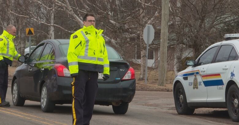 Officers stop a vehicle for a roadside check.