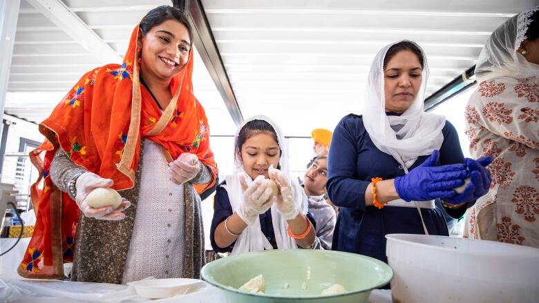 Family members help make aloo tikkis