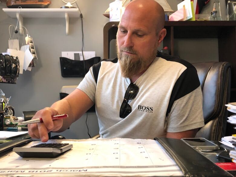 Steve Swyer at his desk working on a calculator.