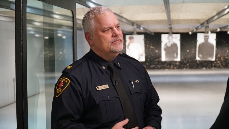 A police officer stands inside a shooting range.