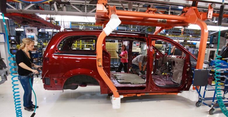 Workers on the production line at Chrysler's assembly plant in Windsor, Ont., work on one of their new minivans on January 18, 2011. A second round of auto worker layoffs in recent months has led politicians to jump to assure workers as the automotive sector undergoes significant transformation. THE CANADIAN PRESS/Geoff Robins