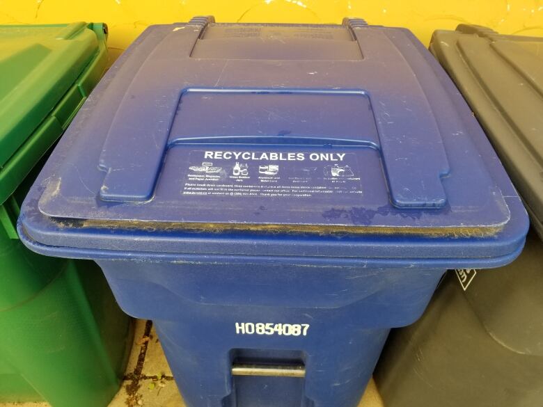 A close-up shot of a blue recycling bin.