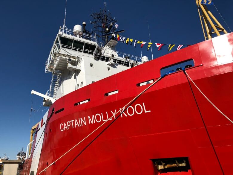 A red and white coast guard ship in dock.