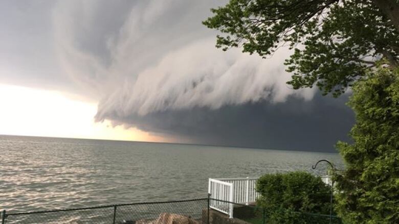 Towering storm clouds over a body of water. 