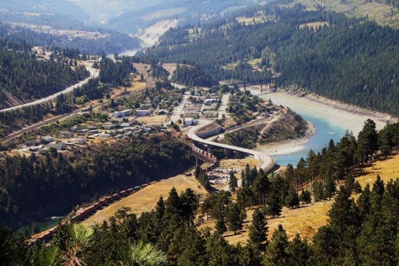 An aerial view of a small community nestled in hills along a river before it burned.