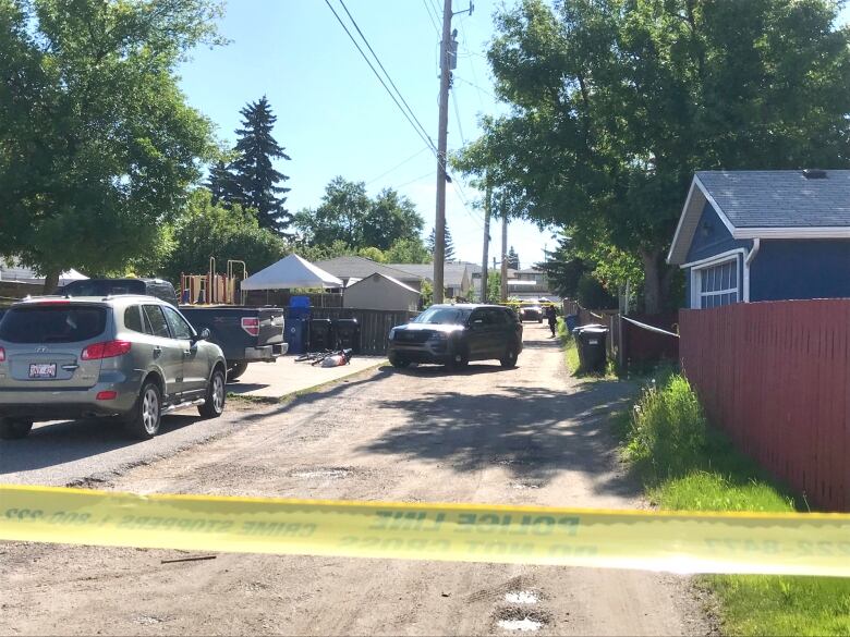 Police tape prevents entrance to an alley. 