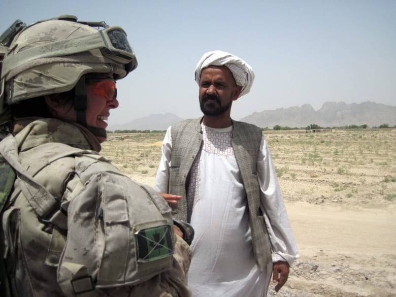 Lt.-Col. Jennie Carignan, commanding officer of the Engineer Regiment of Canada's Task Force Kandahar, speaks to area resident Yar Mohammad about a retaining wall project near his village along the Tarnak River in the Dand Distrct of Kandahar province on August 12, 2010.