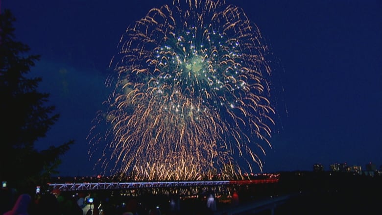 Dark yellow fireworks are seen stacked on top of each other against a dark blue sky. 