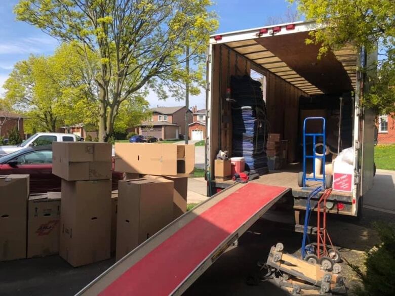 Cardboard boxes surround a half-filled moving truck.