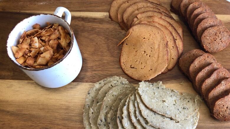 plant-based meats across a wooden platter with more small food cut up in a small cup.