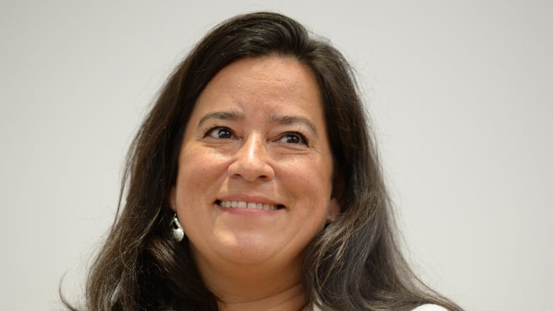 A woman with brown hair smiles.