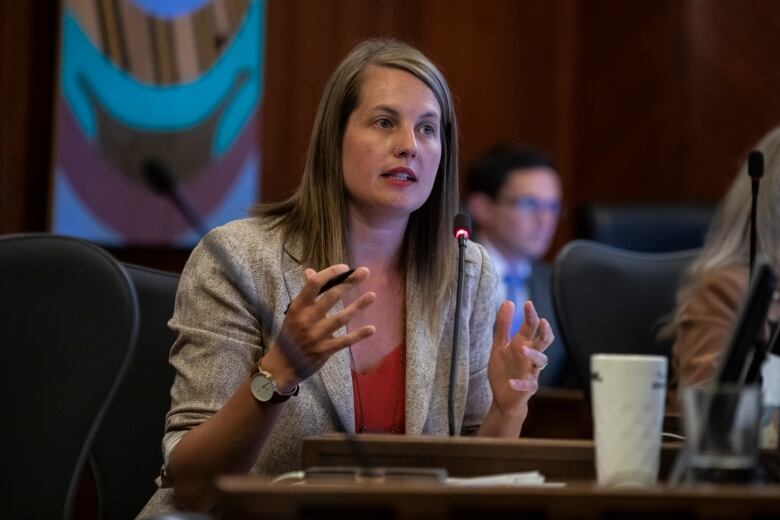 A woman gestures as she speaks in council.