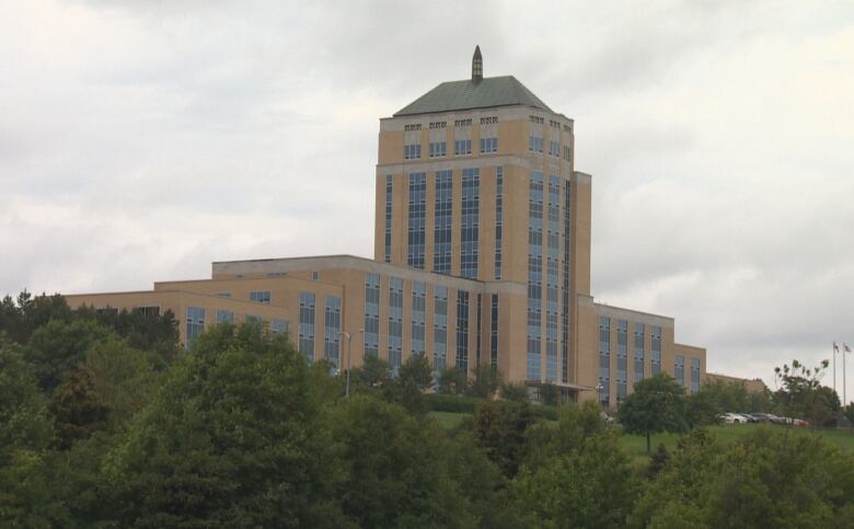 A large government building surrounded by green trees. 