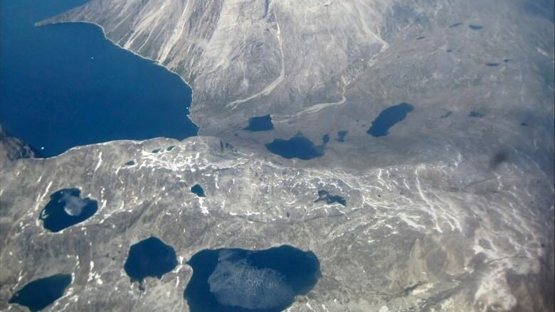 An aerial view of melt water lakes on the edge of an ice cap in Nunatarssuk, Greenland. 