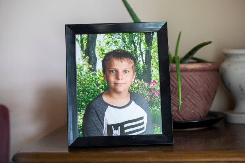 A picture at his grandfathers home of Carson Crimeni in Langley, British Columbia on Aug. 9, 2019. Carson is smiling in the photograph where he is shown from the shoulders up in front of a garden. He has blonde hair and looks about 12 in the picture.