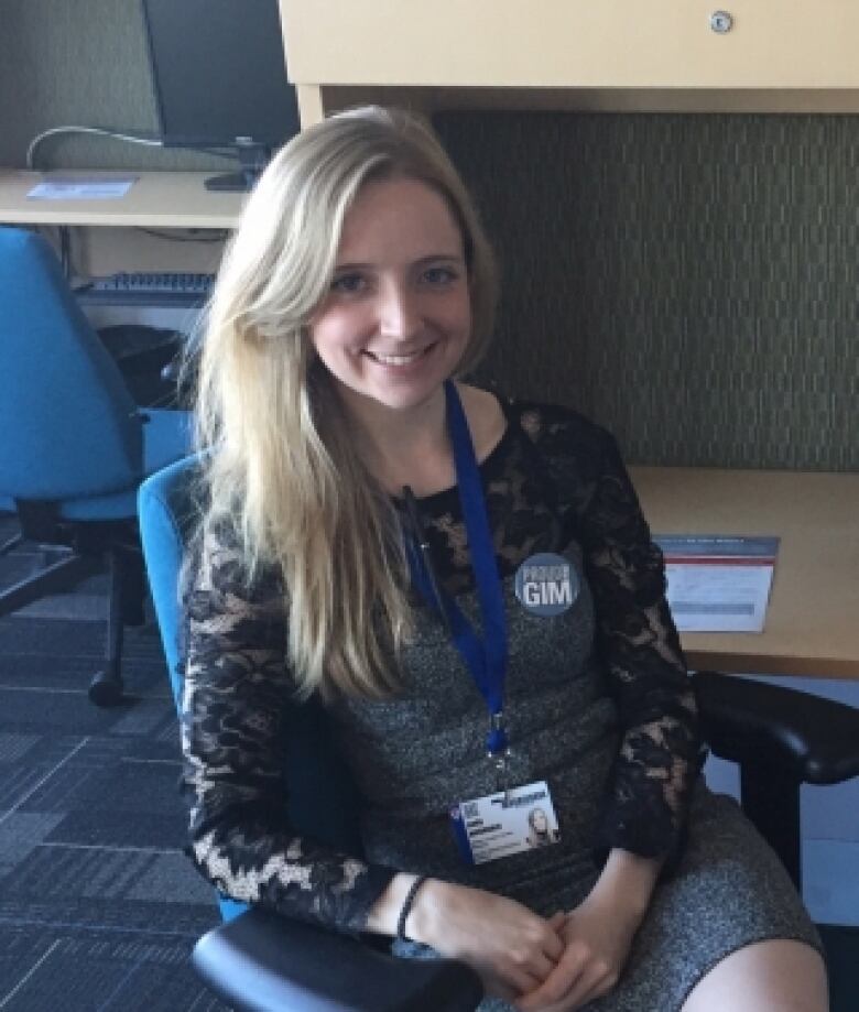 Woman with blonde hair seated in an office. 