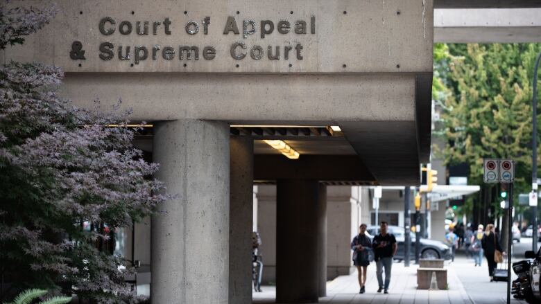 A building featuring a concrete overhang, with the label Court of Appeal & Supreme Court on the side, supported by two large pillars.