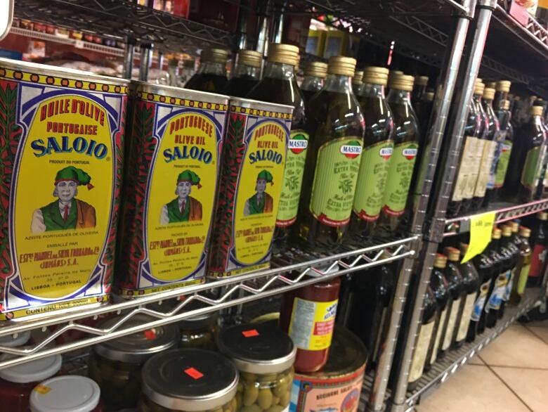 Several olive oil bottles sit on some shelves.