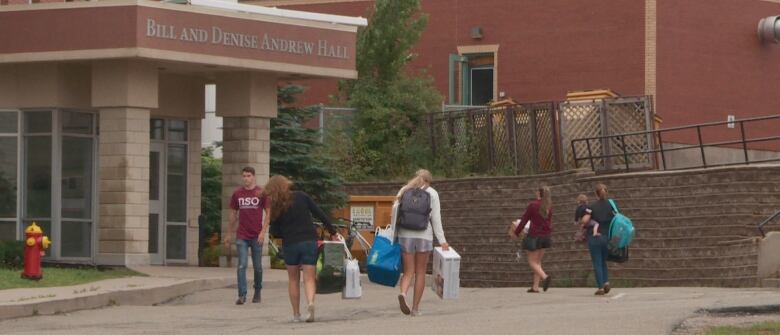 Students bring luggage into a University of Prince Edward Island residence in August 2019. 