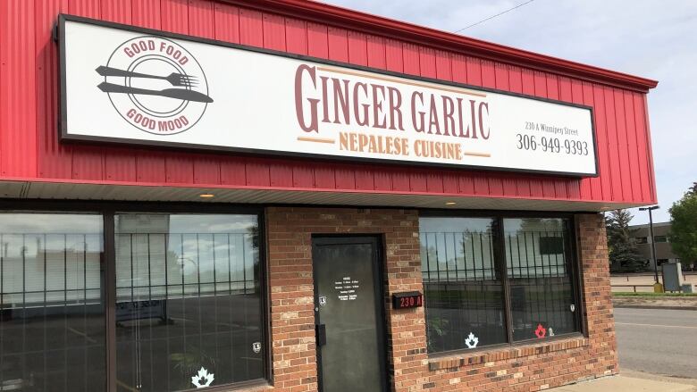 The exterior of a restaurant with a large sign baring its name.