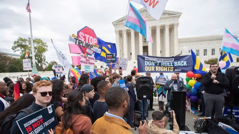 A large group of people holding signs, with messages such as 