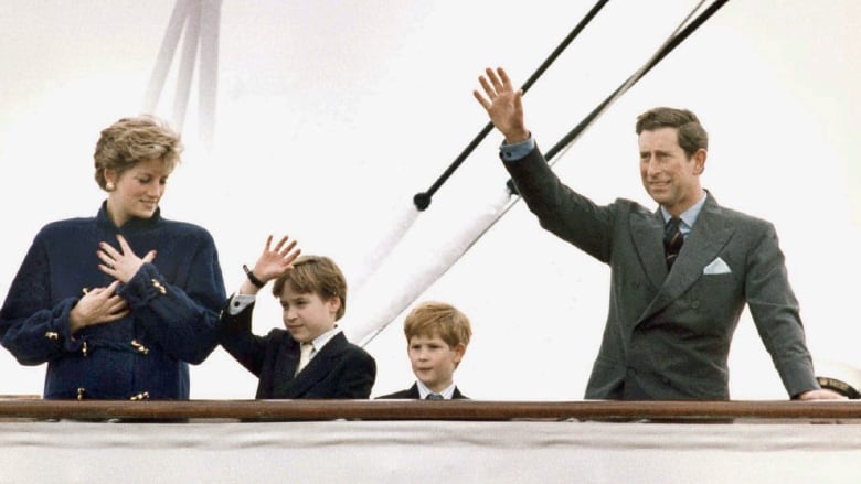 Woman, waving man and two young boys on deck of a ship