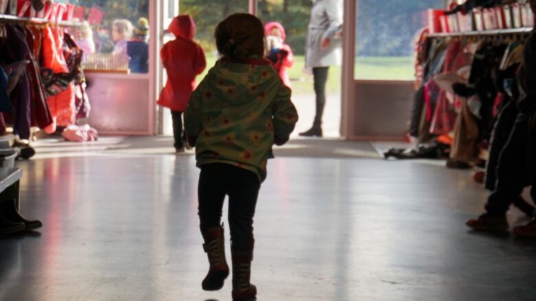 A child in a school head towards an open door and out into the school yard