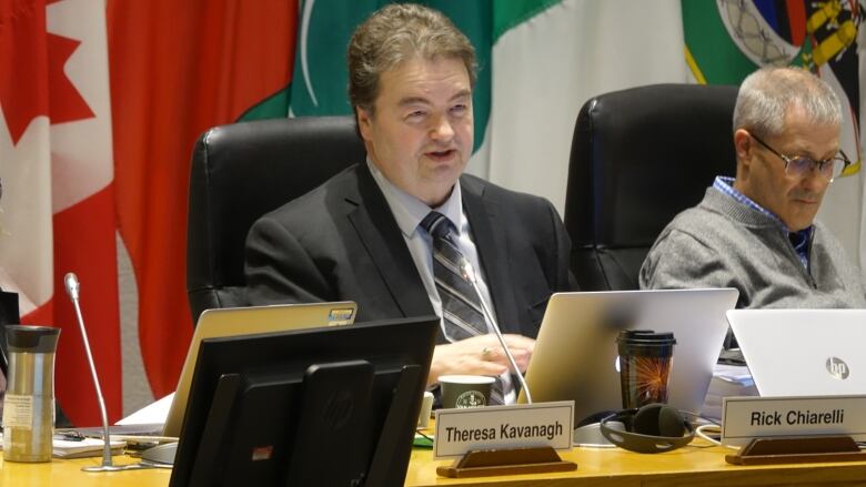 A man sits at the desk in council chambers