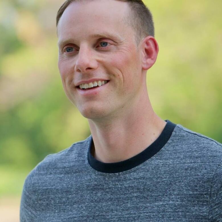 A portrait of a man in a T-shirt, smiling.