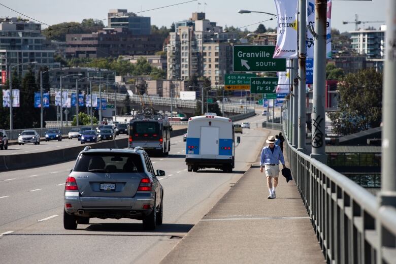 A pedestrian walks along the Granville Street Bridge in Vancouver on Sept. 6, 2019.