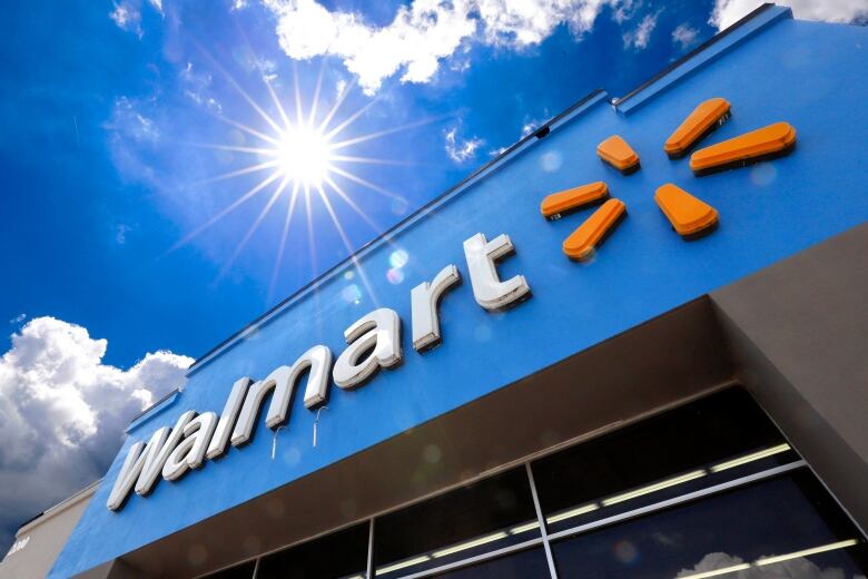 A closeup of a Walmart building against a sunny sky. 