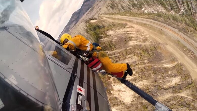 An image from a video showing a firefighter rappelling from a helicopter.